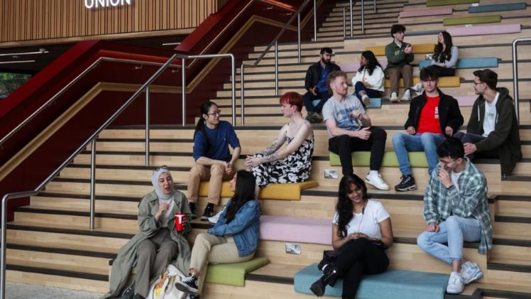 students sat together chatting on One Elmwood staircase